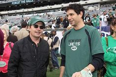 two men standing next to each other at a football game