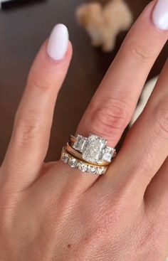 a woman's hand with two rings on it and one ring in the middle