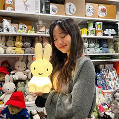 a woman holding up a stuffed rabbit toy