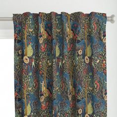 the curtain is hanging in front of a window with blue and green floral designs on it