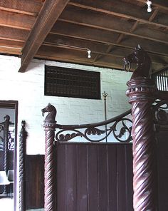 an iron gate in the middle of a room with wooden floors and beams on either side