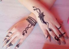 a woman's hands with hennap tattoos on her left arm and wrist