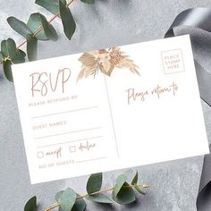 a wedding rsp card sitting on top of a table with eucalyptus leaves and ribbon