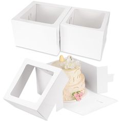 three white boxes with one cake in the middle and two on the side, each containing a single piece of wedding cake