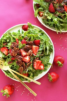 strawberry arugula salad with pecans and strawberries on the side in two white bowls