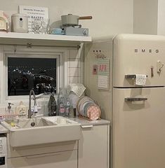 a kitchen area with sink, refrigerator and window