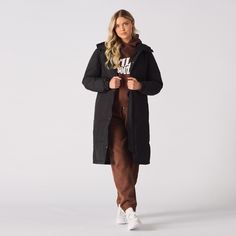 "Our Longline Puffer Coat in Black, a seamless blend of style and functionality for the winter season. This long puffer coat offers a regular fit for comfort and a chic silhouette. It features an adjustable hood and high collar for protection against the elements, with a convenient zip and press-stud fastening for easy wear. The two side pockets add style and practicality, while its shower-resistant properties ensure you stay dry and comfortable. This durable and high-quality coat is an essential addition to any winter wardrobe. Product Features: Long puffer coat Regular fit Adjustable hood High collar Zip and press-stud fastening 2 Side pockets Water Proof 100% Polyester Our Model is 5'6\" and Wears Size M. To find the perfect fit for yourself, check our Size Guide Size = M - L Chest = 59 Rain Coat Women, Long Quilted Jacket, Vintage Jackets Women, Women's Puffer Coats, Grey Denim Jacket, Parka Women, Long Puffer Coat, Womens Jackets Casual, Long Puffer