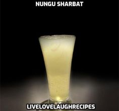 a tall glass filled with liquid sitting on top of a black table next to the words nungi sharbat