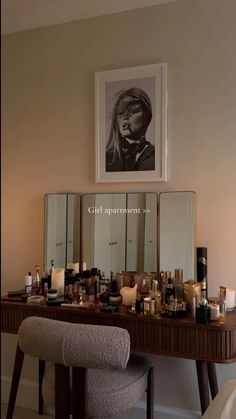 a vanity with candles and pictures on the wall next to it in front of a mirror