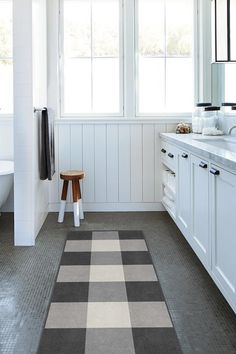 a bathroom with white walls and gray flooring