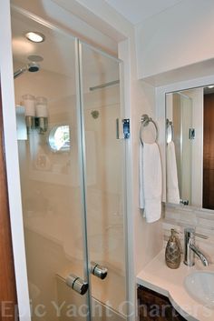 a bathroom with a sink, shower and mirror