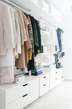 a white closet filled with lots of clothes