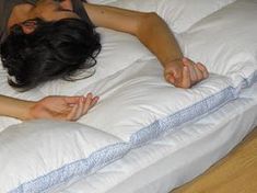 a woman laying on top of a white pillow