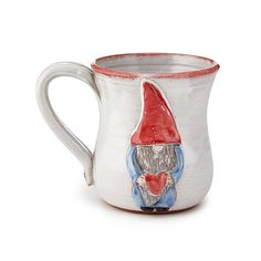 a white and red mug with a gnome holding a heart on the inside of it