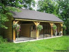 a dog house with two dogs in it and some flowers on the fence around it