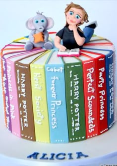 there is a cake made to look like a book with an elephant sitting on top