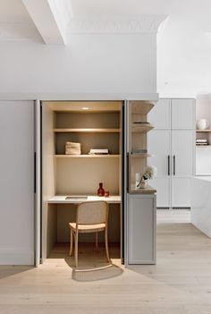 an open closet with a desk and chair in the corner, next to a kitchen counter