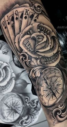 a man's arm with a clock and playing cards on it