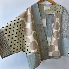 a polka dot kimono is hanging on a hanger and it's made out of fabric