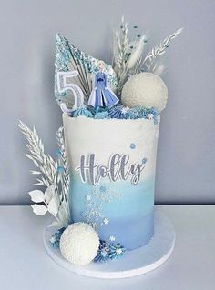 a blue and white frosted birthday cake with snowflakes on the top that says 5 hollies