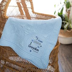 a blue blanket sitting on top of a wicker chair next to a potted plant