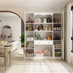 a dining room with white walls and wooden flooring, an arched doorway leading to the kitchen