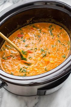 a wooden spoon in a slow cooker filled with soup