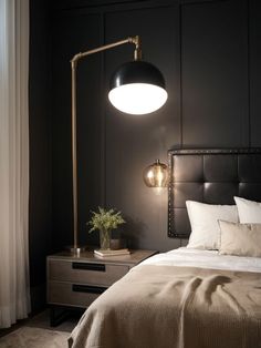 a bedroom with black walls and white bedding