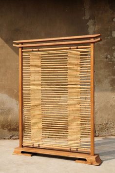 a wooden frame sitting on top of a cement floor next to a wall with a window