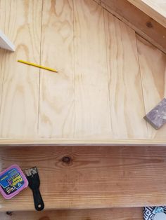 tools are sitting on top of a wooden shelf with plywood and glue in the background