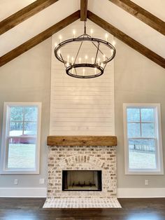 a living room with a fire place in the center and two windows on both sides