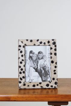 a black and white photo frame sitting on top of a wooden table