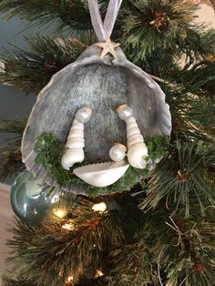 an ornament hanging from the top of a christmas tree with seashells on it