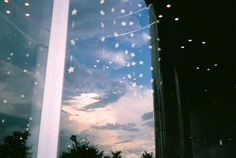 the sky is reflected in the windows of an office building at dusk with stars on them