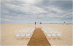 an empty beach with rows of white chairs set up for a wedding on the sand