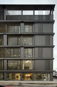 an office building with many windows on the front and side of it's facade