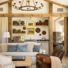 a living room filled with furniture and a chandelier hanging over the top of it