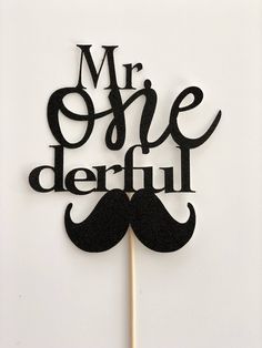 a cake topper with the words mr one derful on it and a moustache