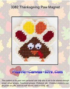 a cross stitch thanksgiving turkey ornament with leaves and acorns on it