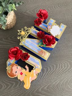 some paper flowers are sitting on top of a card holder with other items in the background