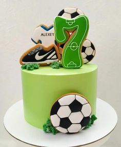 a green cake with soccer themed decorations on it's top and the number seven