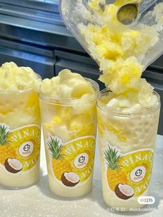 three cups filled with ice cream and pineapple toppings