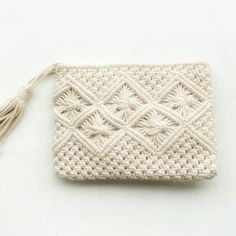 a white crocheted purse with tassels