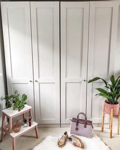 a bedroom with white closet doors and shoes on the floor next to a pink chair