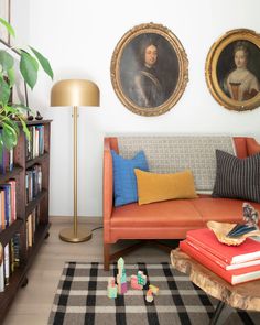 a living room with two paintings on the wall and a couch in front of it