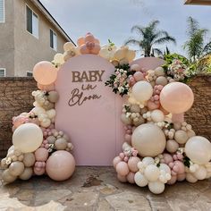 balloons and flowers decorate the entrance to a baby shower