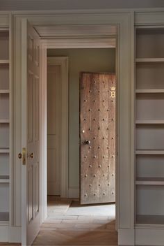 an open door leading to another room with built - in bookcases on either side