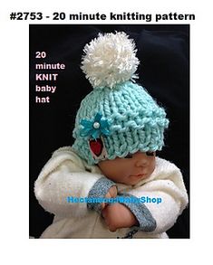 a baby wearing a knitted hat with pom - poms