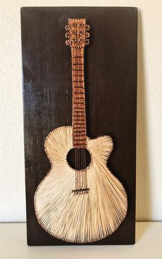 an art piece with a guitar made out of reeds on the bottom of it