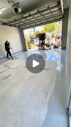 a man is cleaning the garage floor with a mop